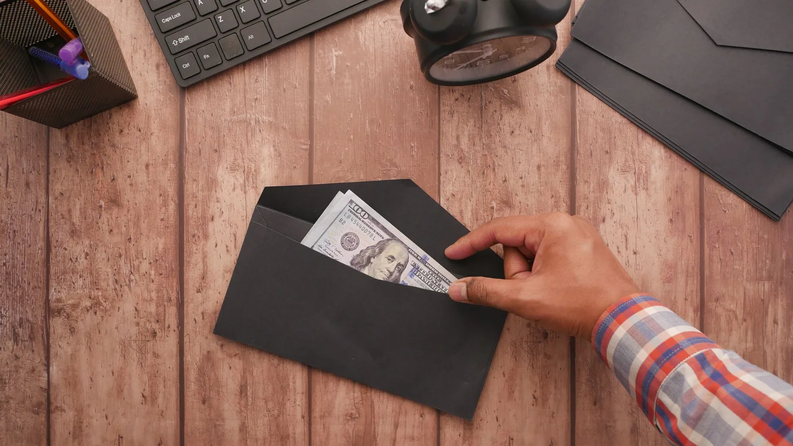 Persona revisando sus opciones de ahorro ante una mesa con documentos y teléfono